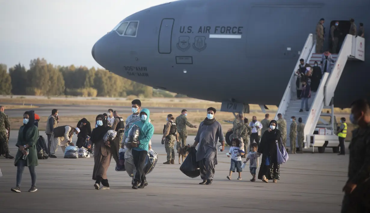 Pengungsi dari Afghanistan turun dari pesawat angkatan udara AS di Naval Station di Rota, Spanyol selatan, Selasa (31/8/2021).  Amerika Serikat menyelesaikan penarikannya dari Afghanistan Senin malam, mengakhiri perang terpanjang Amerika. (AP Photo/Marcos Moreno)