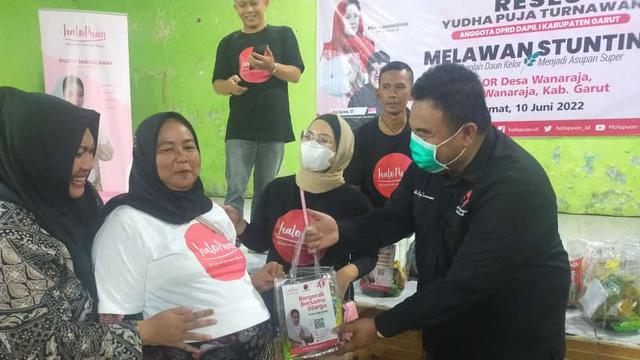 Ketua DPD PDIP Garut Yuda Puja Turnawan tengah memberikan paket makanan tambahan bagi ibu hamil dan menyusui di sela-sela reses yang dibungkus dalam kegiatan penyuluhan kesehatan pencegahan stunting. (Liputan6.com/Jayadi Supriadin)