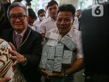 Maqdir Ismail, kuasa hukum terdakwa korupsi BTS 4G, Irwan Hermawan, tiba di Gedung Bundar Jaksa Agung Muda Bidang Tindak Pidana Khusus (Jampidsus) Kejaksaan Agung (Kejagung) RI, Kamis (13/7/2023) pagi. (Liputan6.com/Faizal Fanani)