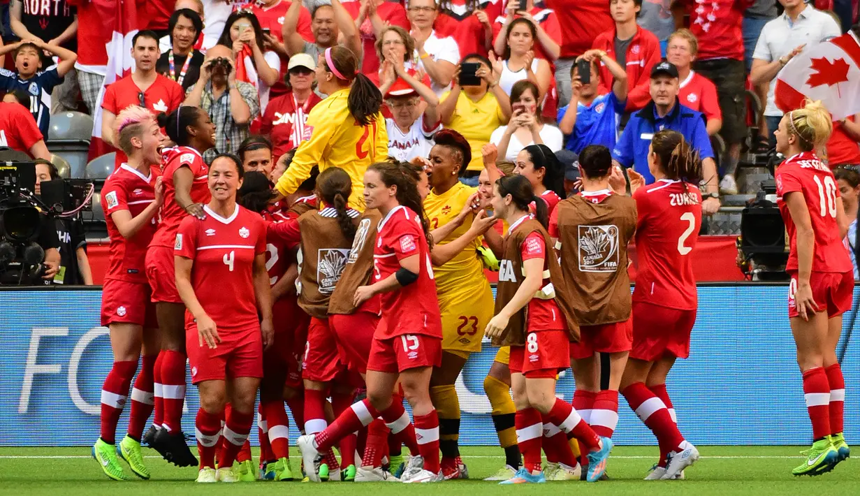 Bek Kanada, Josee Belanger (kanan) bersama Selenia Iacchelli menyapa fansnya usai pertandingan di Piala Dunia wanita 2015 di BC Place Stadium, Senin (22/6/2015). Kanada menang 1-0 atas Swiss lewat gol Josee Belanger. (Reuters/Anne Marie Sorvin)