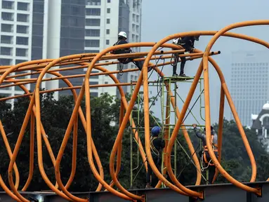 Aktivitas pekerja saat menyelesaikan pembangunan Sky Walk Kebayoran Lama, Jakarta, Selasa (11/10/2022). Jembatan penyebrangan orang (skywalk) ini dibangun untuk mendukung integrasi antarmoda transportasi. (Liputan6.com/JohanTallo)