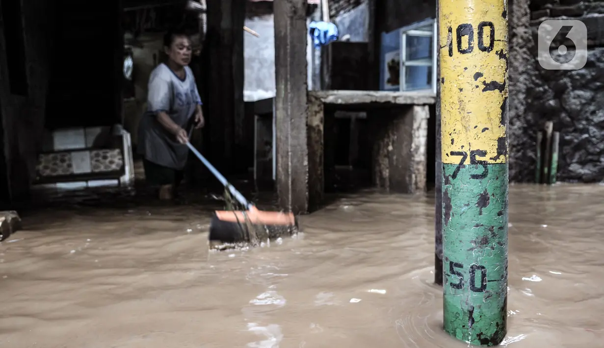 Warga membersihkan lumpur di permukiman Kebon Pala, Jatinegara, Jakarta, Minggu (25/10/2020). Hampir 12 jam banjir kiriman dari Bogor itu masih merendam permukiman warga di RT 11 RW 05 Kebon Pala dengan ketinggian mencapai pinggang orang dewasa.  (merdeka.com/Iqbal Nugroho)