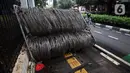 Pejalan kaki berjalan menghindari kawat berduri yang berada di trotoar Jalan Asia Afrika, Jakarta Pusat, Selasa (28/12/2021). Kawat berduri yang berada di trotoar tersebut sangat mengganggu para pejalan kaki yang melintas. (Liputan6.com/Johan Tallo)