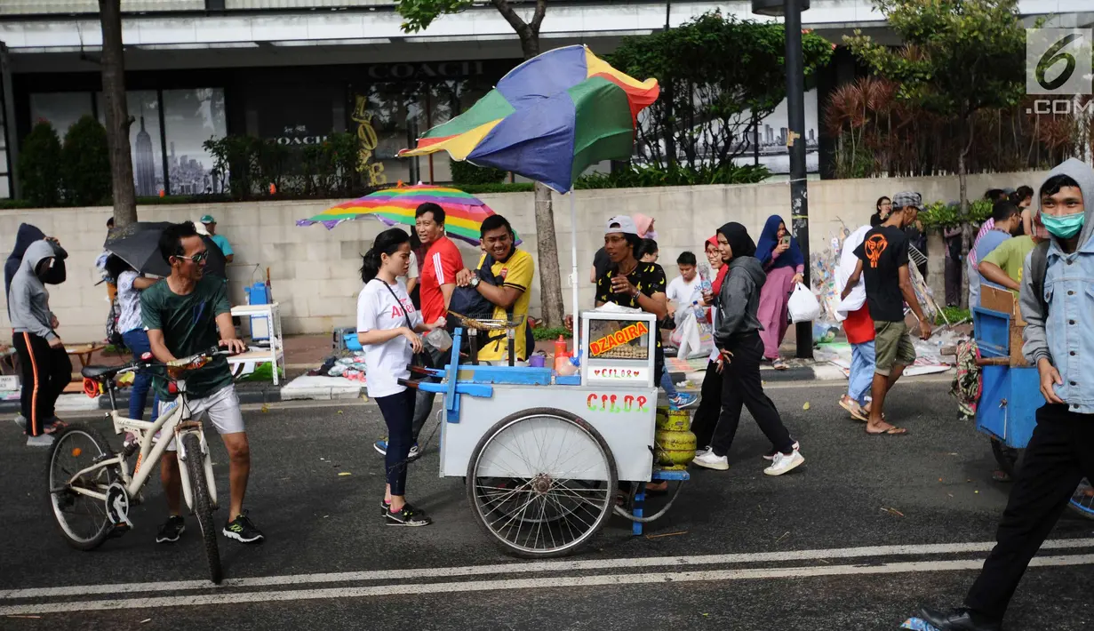 Suasana saat angin kencang berhembus di sekitar Bundaran Hotel Indonesia, Jakarta, Minggu (26/11). Angin kencang dan gerimis terjadi saat kegiatan Hari Bebas Kendaraan, Minggu pagi. (Liputan6.com/Helmi Fithriansyah)