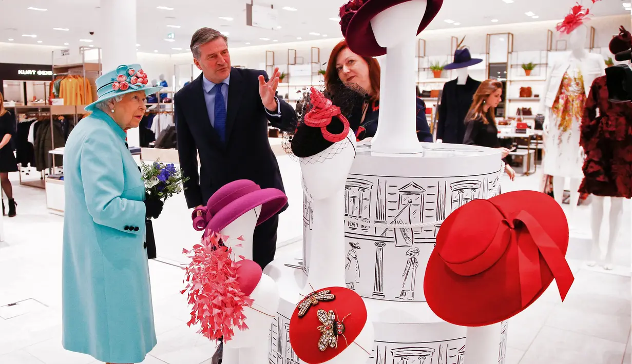 Ratu Elizabeth II melihat-lihat aksesoris topi di department store Fenwick saat mengunjungi pusat perbelanjaan Lexicon di Bracknell, London, Jumat (19/10). Saat berbelanja, area tersebut dikosongkan hanya untuk Ratu Elizabeth. (HENRY NICHOLLS/ POOL/AFP)