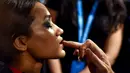 Seorang model India saat dirias oleh kru makeup di belakang panggung sebelum tampil di catwalk selama Lakmé Fashion Week (LFW) Summer Resort 2019 di Mumbai, India (31/1). (AFP Photo/Sujit Jaiswal)