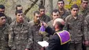 Pendeta Aristakes Hovhannisyan membaptis tentara etnis Armenia di sebuah kamp militer dekat garis depan konflik di wilayah separatis Nagorno-Karabakh, Azerbaijan, Senin (2/11/2020). Pasukan Armenia dan Azerbaijan saling menyalahkan atas serangan baru selama perebutan Nagorno-Karabakh. (AP Photo)