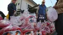 Seorang pedagang menjajakan boneka merah Daruma dalam pameran tahunan Oume Daruma di Tokyo, Jepang, 12 Januari 2018. Boneka ini biasanya dicat dengan warna merah lantaran warna merah dianggap memiliki kekuatan menolak bala.. (AP/Koji Sasahara)