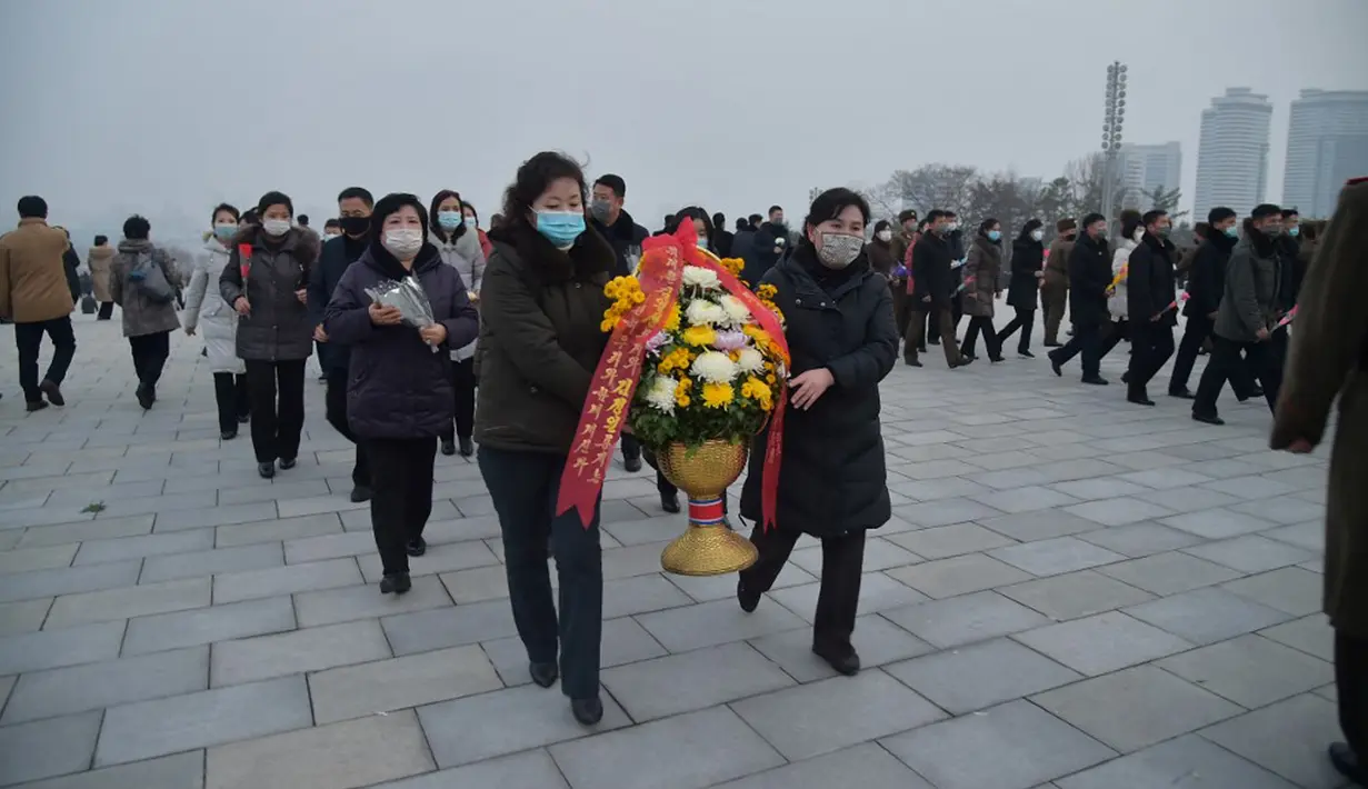 Warga berdatangan untuk memberi penghormatan di depan patung mendiang pemimpin Korea Utara Kim Il-sung dan Kim Jong-il pada peringatan 10 tahun kematian Kim Jong-il, Pyongyang, Korea Utara, 16 Desember 2021. Kim Jong-il adalah ayah dari pemimpin Korea Utara saat ini, Kim Jong-un. (KIM WON JIN/AFP)