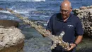 Jacob Sharvit dari Israel Antiquities Authority memperlihatkan pedang berusia 900 tahun yang diyakini milik seorang tentara salib di Caesarea pada 19 Oktober 2021. Seorang penyelam amatir menemukan pedang tersebut dari dasar laut Mediterania.  (JACK GUEZ / AFP)