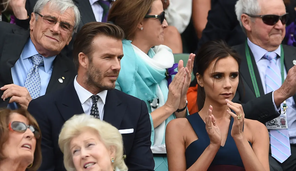 Meski tanpa ekspresi dan tetap dengan tatapan tajamnya, Victoria Beckham tetap memberi tepuk tangan saat menonton pertandingan tenis di Kejuaraan Wimbledon, Inggris (6/7/2014) bersama sang suami. (Bintang/EPA)