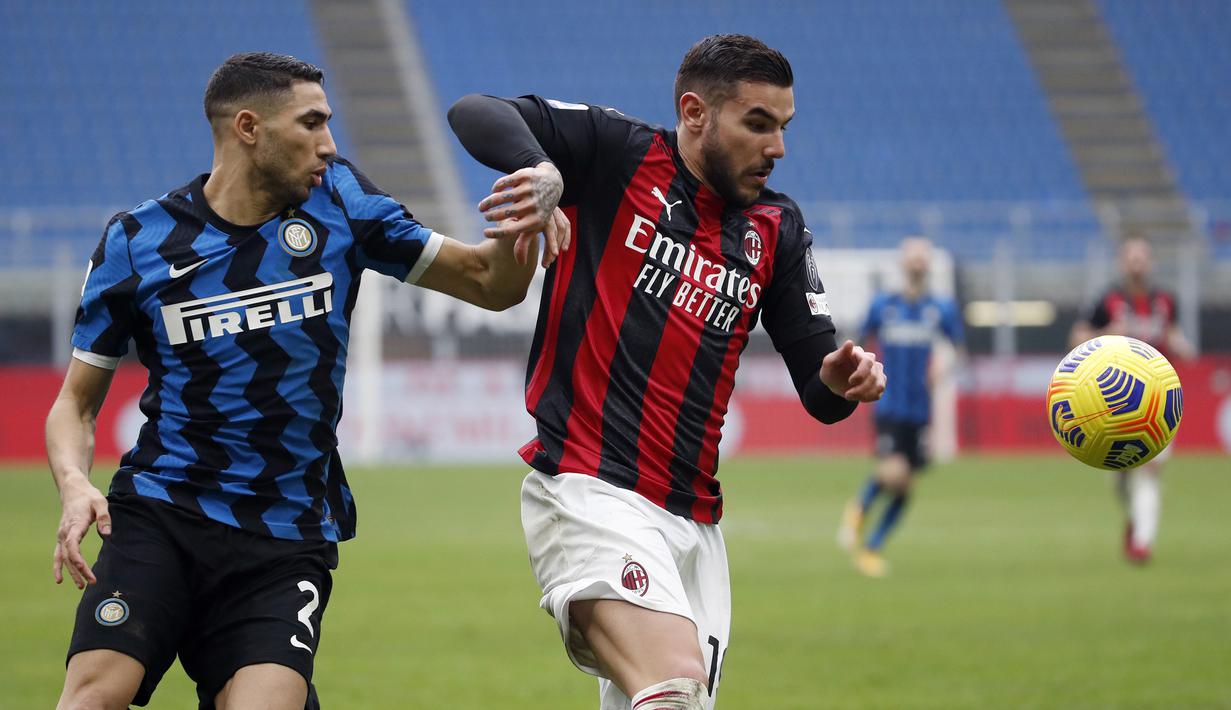 Bek AC Milan, Theo Hernandez (kanan) menguasai bola dibayangi bek Inter Milan, Achraf Hakimi dalam laga lanjutan Liga Italia 2020/21 pekan ke-23 di San Siro Stadium, Minggu (21/2/2021). AC Milan kalah 0-3 dari Inter Milan. (AP/Antonio Calanni)