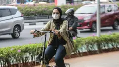Warga melintas memakai masker untuk melindungi diri dari debu di Jalan Sudirman,Jakarta, Selasa (15/8/2023). (Liputan6.com/Faizal Fanani)