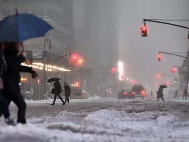 Warga berjalan di New York, yang terkena dampak badai salju, Selasa (14/3). Badai salju menghantam hampir separuh wilayah Amerika Serikat ketika sebagian besar wilayah Pantai Timur mengalami badai musim dingin paling buruk. (Jewel SAMAD/AFP)