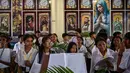 Paduan suara gereja Katolik mempersiapkan daun palem selama prosesi untuk menandai Minggu Palem di Gereja Kelahiran Bunda Maria, yang juga dikenal sebagai Gereja Katolik Kelahiran Santa Perawan Maria, di Surabaya pada 13 April 2025. (JUNI KRISWANTO/AFP)