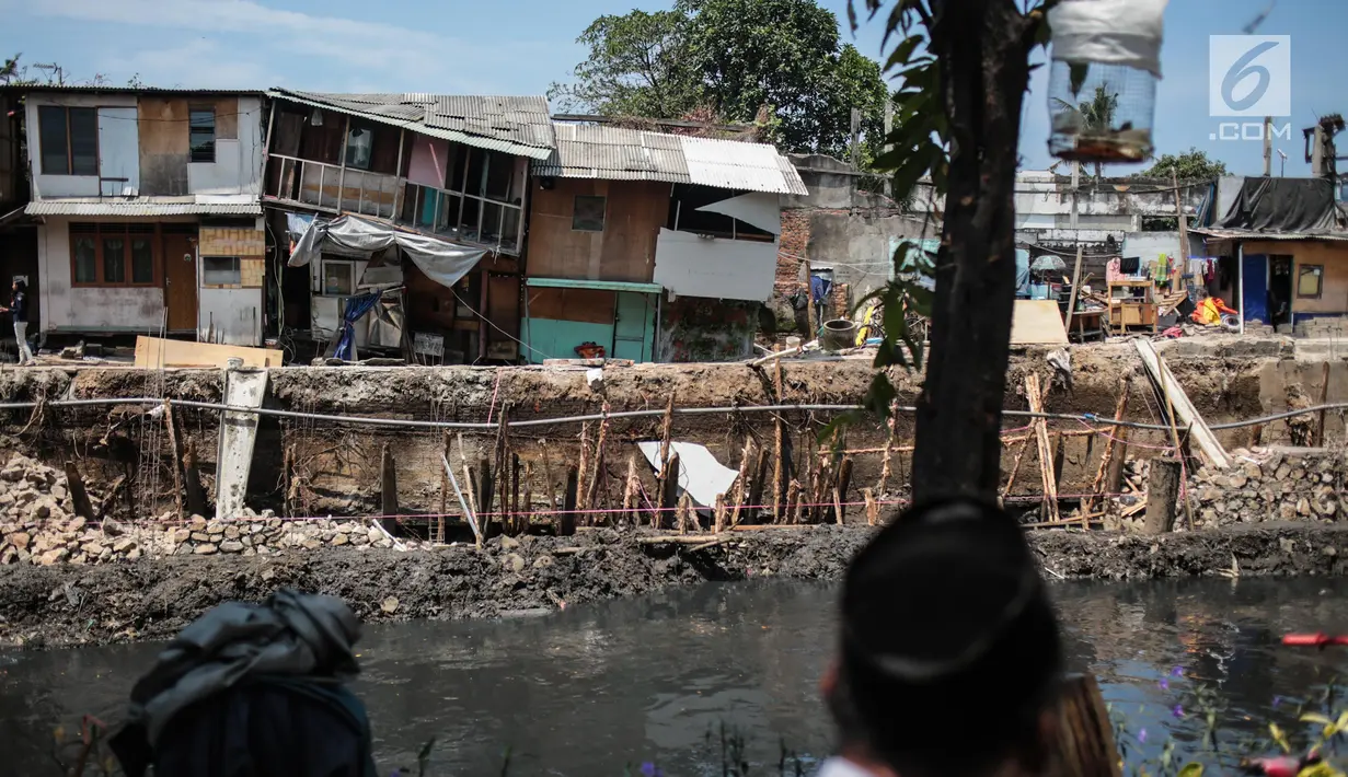 Sejumlah rumah hampir ambruk akibat amblesnya tanah di bantaran Anak Kali Ciliwung di Jalan Lodan Raya, Pademangan, Jakarta, Senin (19/11). Amblesnya bangunan akibat pengerukan untuk normalisasi kali dan pemasangan turap. (Liputan6.com/Faizal Fanani)