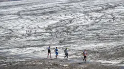 Sejumlah pelari melintas di Glacier Tsanfleuron saat mengikuti Glacier 3000 Run and Marathon di Les Diablerets, Swiss (5/8). Peserta lomba lari harus melewati lintasan sepanjang 42km dengan ketinggian 2.807 meter. (AFP Photo/ Fabrice Coffrini)