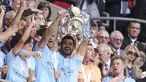 Kapten tim Manchester City, Ilkay Gundongan, mengangkat trofi Piala FA setelah berhasil membawa timnya keluar sebagai juar di partai final FA Cup 2022/2023 melawan Manchester United yang berlangsung di Wembley Stadium, Sabtu (3/6/2023). (AP Photo/Dave Thompson)
