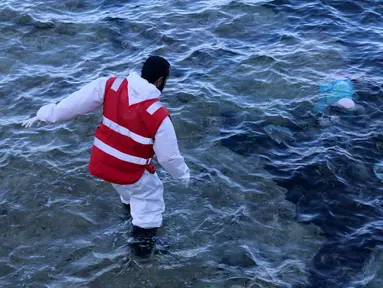 Seorang petugas menemukan mayat yang terapung di pantai di Kota Pesisir Tajoura, Libya, Minggu (4/12). Diduga orang yang tenggelam itu akan meninggalkan Libya karena berharap dapat menjadi imigran di negara lain. (REUTERS / Hani Amara)