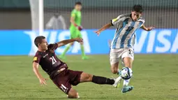 Pemain Timnas Argentina U-17, Valentino Acuna (kanan) berebut bola dengan pemain Timnas Venezuela U-17, Nicola Profeta pada laga 16 besar Piala Dunia U-17 2023 di Stadion Si Jalak Harupat, Bandung, Selasa (21/11/2023). (Bola.com/Ikhwan Yanuar)