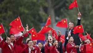 Atlet China mengibarkan bendera saat parade acara pembukaan Olimpiade 2024 di Paris, Sabtu (27/7/2024). (Steph Chambers/Pool Photo via AP)