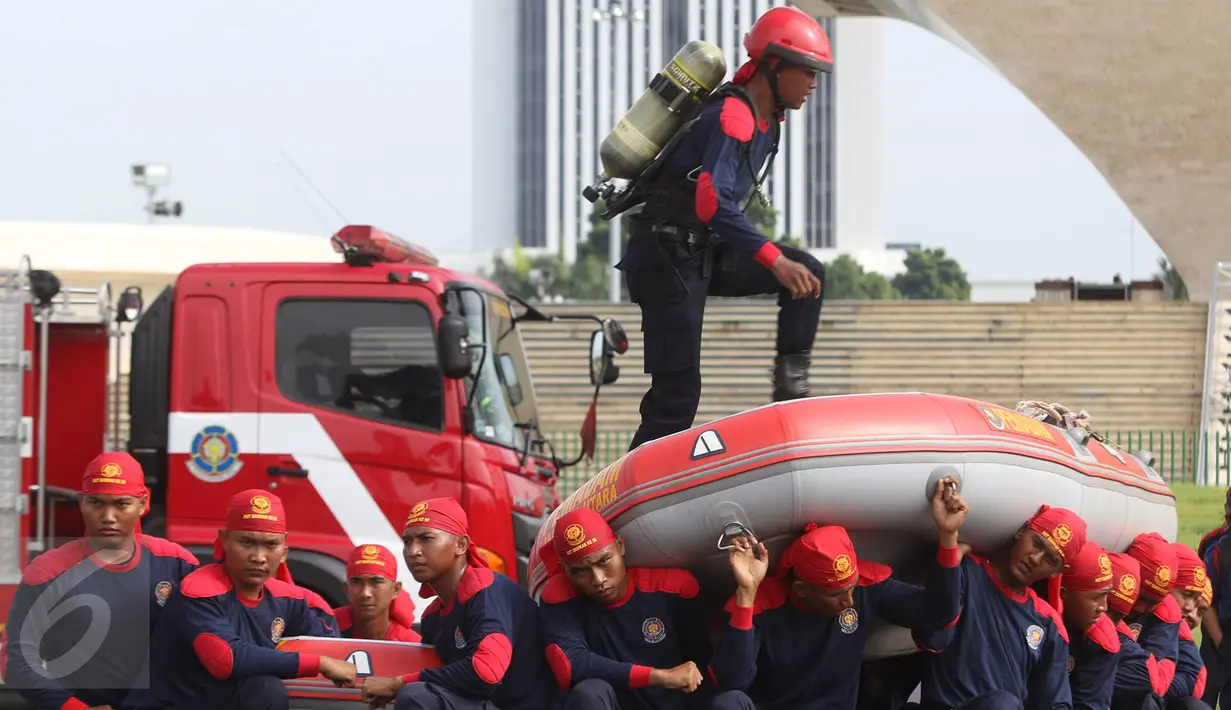 Aksi personel pemadam kebakaran saat demostrasi kemampuan dalam acara Upacara Perayaan Ulang Tahun Pemadam Kebakaran (Damkar) ke-98 di Lapangan Silang Monas Selatan, Jakarta Pusat, Rabu (1/3). (Liputan6.com/Immanuel Antonius)