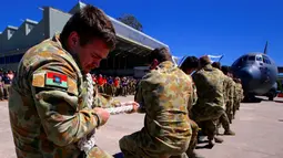 Ekspresi anggota Royal Australian Air Force saat mengikuti lomba menarik pesawat Hercules C-130J saat di Pangkalan Udara Richmond, Sydney (24/11). Lomba ini sebagai kegiatan melatih ketangkasan sekaligus kebersamaan. (REUTERS/David Gray)