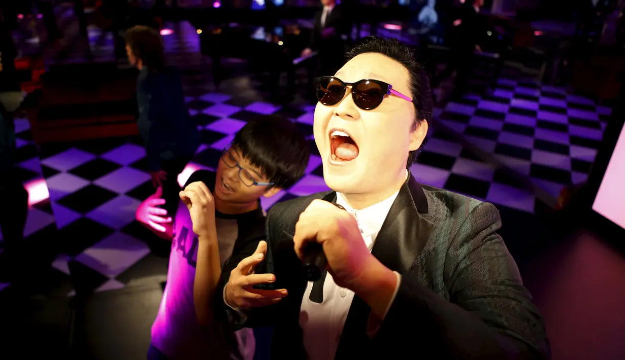Seorang anak berpose bersama patung lilin penyanyi Korea Selatan Psy di Grevin Wax Museum, Korea Selatan, Kamis (30/7/2015). Korea menjadi negara pertama yang membuka Grevin Wax Museum milik Perancis. (REUTERS/Kim Hong-Ji)