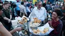 Dubes Inggris Moazzam Malik berbincang saat membeli gorengan untuk berbuka puasa di kawasan Museum Fatahilah, Jakarta, Minggu (18/6). Dalam kesempatan itu, Dubes Inggris untuk Indonesia Moazzam Malik bicara soal toleransi. (Liputan6.com/Gempur M Surya)