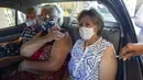 Tiga orang dalam mobil mendapatkan suntikan vaksin COVID-19 Sinovac sebagai bagian dari program vaksinasi prioritas untuk lansia di lokasi drive-thru yang didirikan di tempat parkir stadion sepak bola Pacaembu, Sao Paulo, Brasil, Rabu (3/3/2021). (AP Photo/Andre Penner)