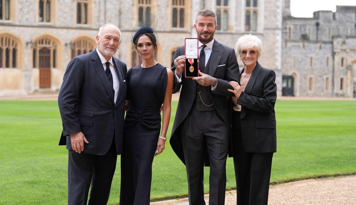 Mantan pesepak bola, David Beckham (tengah kanan) bersama istri dan kedua orang tuanya berfoto bersama dengan medali setelah upacara penganugerahan gelar Ksatria oleh Raja Inggris, Charles III di Kastil Windsor, Berkshire, Inggris, Selasa (04/11/2025) waktu setempat. (AP Photo/Pool/Andrew Matthews)