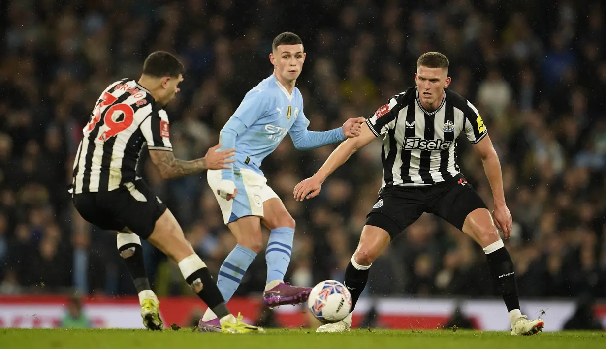 Phil Foden dari Manchester City dikawal ketat pemain Newcastle United pada laga Piala FA di Stadion Etihad, Minggu (17/3/2024).  (Foto AP/Dave Thompson)