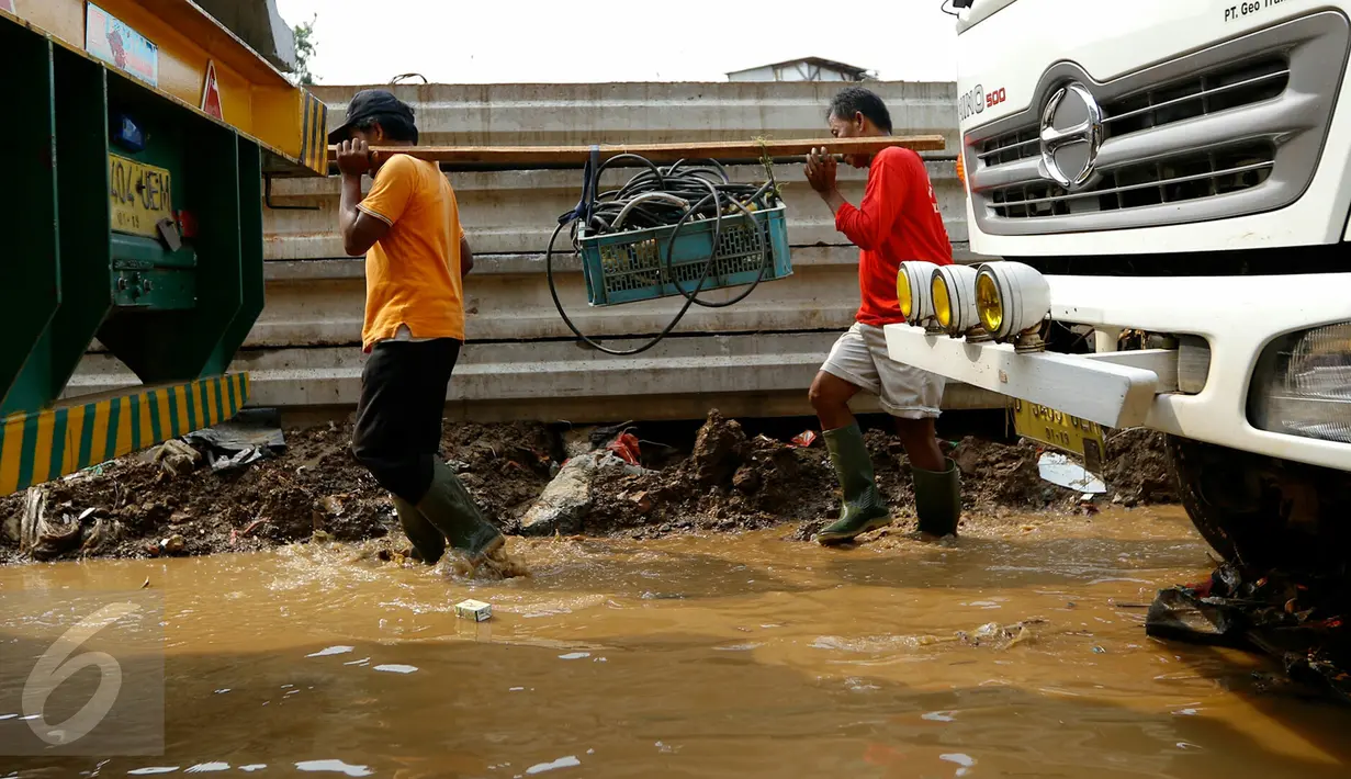 Petugas normalisasi Ciliwung membawa perlengkapan pompa penguras air, Kampung Pulo, Jakarta, Rabu (25/11/2015). Pompa tersebut untuk mempercepat penyurutan banjir di pemukiman Kampung Pulo. (Liputan6.com/Yoppy Renato)