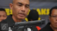 Kasat Reskrim Polres Metro Jaksel AKBP Audie Latuheru menunjukkan sebuah korek api berbentuk revolver saat rilis kasus begal yang kerap beraksi di Mampang Prapatan, Jakarta, Selasa (19/1). Petugas mengamankan dua orang pelaku. (Liputan6.com/Faisal R Syam)