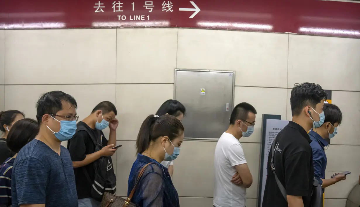 Orang-orang yang memakai masker berjalan melalui stasiun kereta bawah tanah pada jam sibuk pagi hari di Beijing, Rabu (4/8/2021). Wabah virus corona terparah di China sejak awal pandemi satu setengah tahun lalu meningkat pada Rabu dengan lusinan kasus lagi di seluruh negeri. (AP/Mark Schiefelbein)