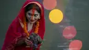 Seorang wanita Nepal berdoa kepada matahari terbenam selama festival Chhath Puja di tepi Sungai Bagmati di Kathmandu, Nepal, Rabu (10/11/2021). Ritual dilakukan untuk berterima kasih kepada Dewa Matahari karena telah menopang kehidupan di bumi. (AP Photo/Niranjan Shrestha)