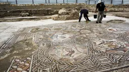 Seorang peneliti sejarah kuno membersihkan sebuah gambar yang ada pada lantai sebuah peradaban pada 1.700 tahun yang lalu di Tel Aviv, Israel, Senin (16/11/2015). Tempat ini telah ada pada zaman Romawi dan periode Bizantium.  (REUTERS/Nir Elias)