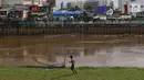 Seorang anak usai bermain sepak bola di bantaran Kanal Banjir Barat, Jakarta, Jumat (5/4). Tidak adanya lapangan menjadikan lokasi tersebut sebagai tempat bermain mereka, meskipun dalam kondisi seadanya. (Liputan6.com/Immanuel Antonius)