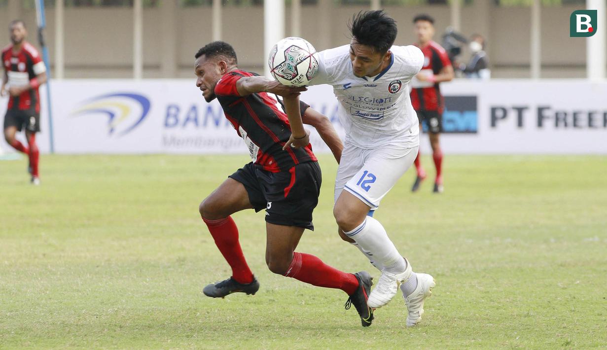 Pemain Arema FC, Rizky Dwi Febrianto (kanan) berusaha melewati pemain Persipura Jayapura, Gunansar Mandowen dalam laga pekan ke-5 BRI Liga 1 2021/2022 di Stadion Madya, Jakarta, Rabu, (29/9/2021). Arema FC menang 1-0. (Bola.com/ M Iqbal Ichsan)