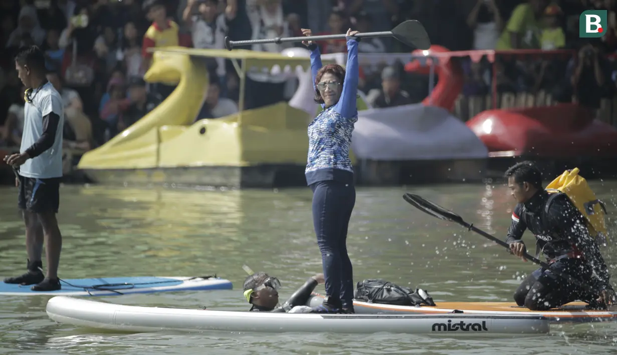 Menteri Kelautan dan Perikanan, Susi Pudjiastuti, menyapa penonton saat bermain paddle board di Danau Sunter, Jakarta, Minggu (25/2/2018). Kegiatan ini dilakukan dalam rangka Festival Danau Sunter. (Bola.com/Okie Prabhowo)