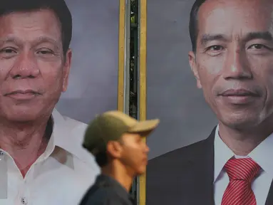 Warga melintas di depan foto Jokowi dan Duterte di Taman Pandang Istana, Jakarta, Kamis (8/9). Rencananya Duterte akan berkunjung ke Indonesia pada Jumat (9/9). (Liputan6.com/Immanuel Antonius)