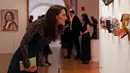 Kate Middleton melihat karya seni saat pameran Portrait Gala 2017 dan penggalangan dana di National Portrait Gallery, London (28/3). Kate Middleton tampil anggun mengenakan gaun berwarna hijau.  (Neil Hall/Pool photo via AP)