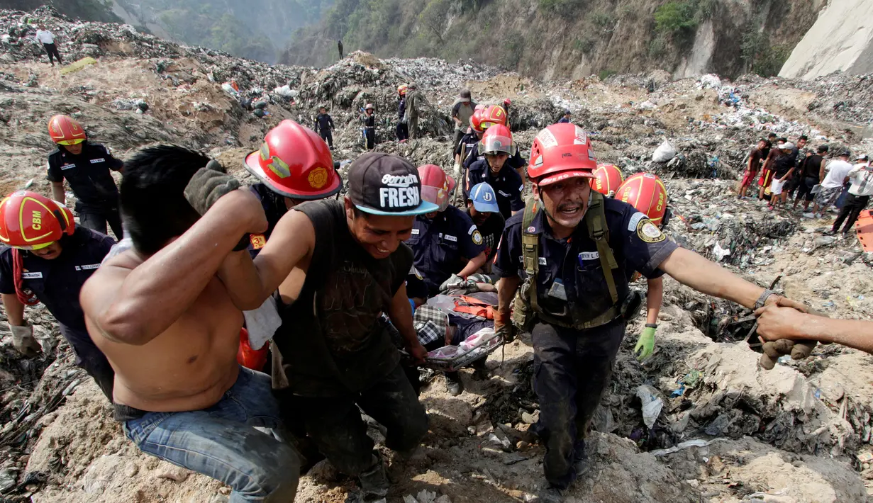 Petugas pemadam kebakaran membawa korban yang luka menggunakan tandu di Tempat Pembuangan Akhir (TPA)  di Guatemala City, Guatemala, Rabu (27/4). Ribuan kubik sampah longsor dan menewaskan satu orang. (REUTERS/Josue Decavele)