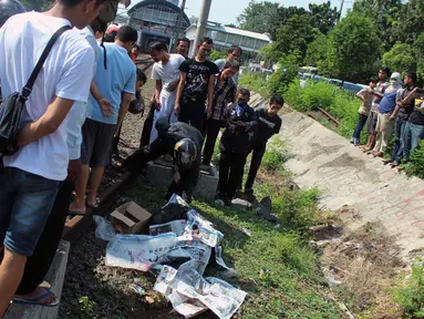 Seorang pria tewas tertabrak kereta api di Palmerah, Jakarta, Jumat, (8/5/2015). Puluhan warga tampak melihat jenazah korban yang tergeletak di pinggir rel. (Liputan6.com/JohanTallo)