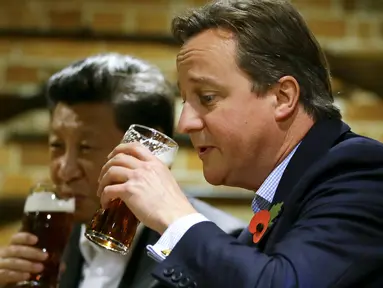 Perdana Menteri Inggris David Cameron (kanan) minum bir bersama Presiden China Xi Jinping di sebuah bar, Inggris, (22/10/2015). Di sela kunjungan ke Inggris, Presiden Cina Xi Jinping diajak PM David Cameron untuk minum bir. (REUTERS/Kirsty Wigglesworth)