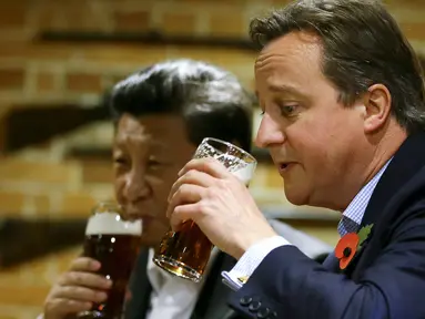 Perdana Menteri Inggris David Cameron (kanan) minum bir bersama Presiden China Xi Jinping di sebuah bar, Inggris, (22/10/2015). Di sela kunjungan ke Inggris, Presiden Cina Xi Jinping diajak PM David Cameron untuk minum bir. (REUTERS/Kirsty Wigglesworth)