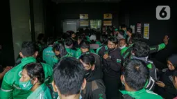 Sejumlah pengemudi ojek online berkerumun saat antre mengambil pesanan di gerai cepat saji McDonald's Raden Saleh, Jakarta, Rabu (9/6/2021). Puluhan driver ojek online terlihat mengabaikan protokol kesehatan saat mengantre pesanan BTS Meal yang mulai dijual. (Liputan6.com/Faizal Fanani)