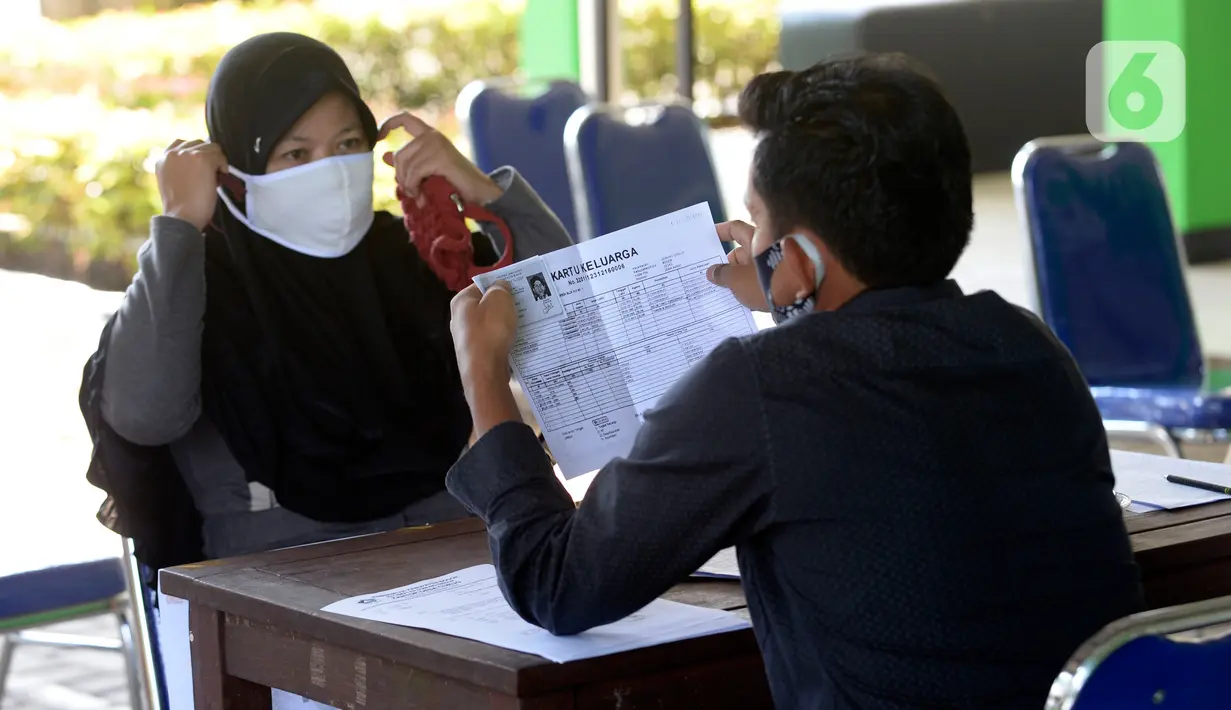 Petugas mengecek data warga Desa Curug di Kantor Desa Curug, Gunung Sindur, Kabupaten Bogor, Jawa Barat, Kamis (17/09/2020). Pemerintah melalui Kementerian Desa, Pembangunan Daerah Tertinggal dan Transmigrasi memberikan BLT-DD tahap lima Rp 300 ribu. (merdeka.com/Dwi Narwoko)