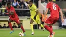 Penyerang Villarreal, Cedric Bakambu (tengah) berusaha membawa bola dari kawalan dua pemain Liverpool pada leg pertama liga Europa di stadion El Madrigal, Spanyol, (28/4). Villarreal menang atas Liverpool dengan skor 1-0. (Reuters / Heino Kalis)