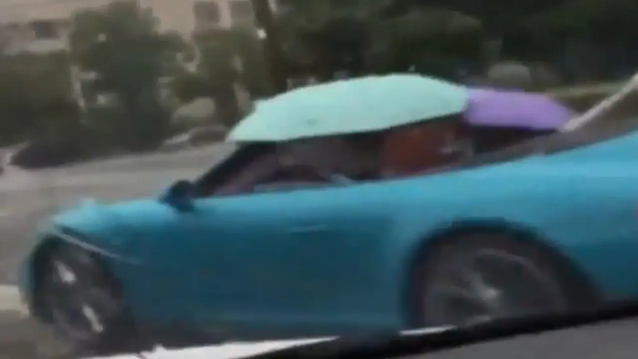 Mobil Mewah Pakai Payung Jadi Atap Saat Hujan Deras